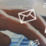 Person typing on laptop with icons of emails floating around