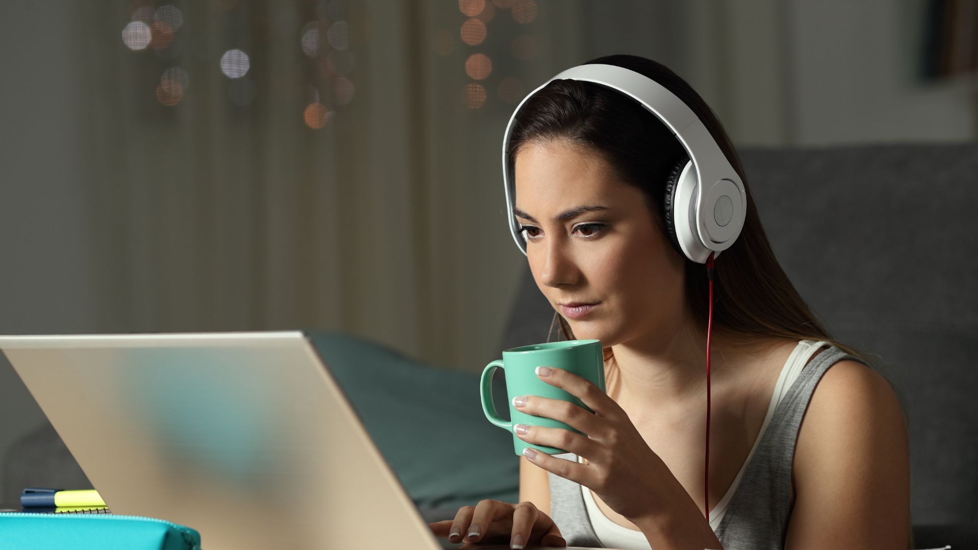 Blog 3 a woman wearing headphones and drinking from a cup